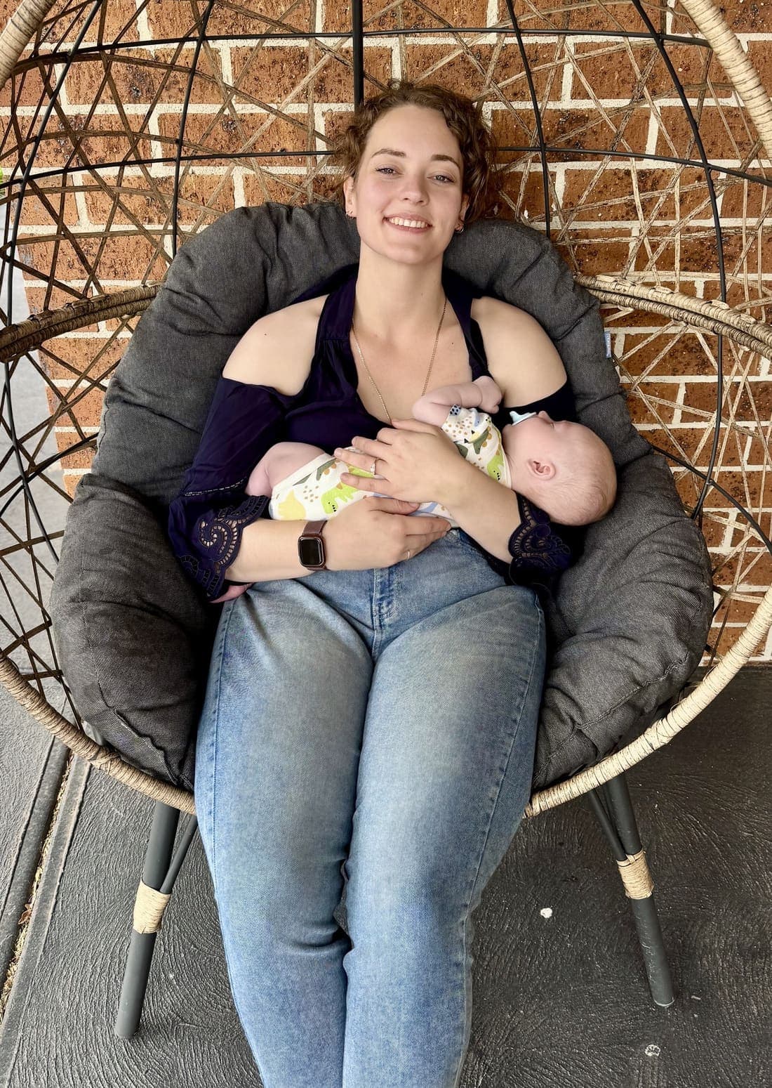 Ksana relaxing in a hanging chair while holding her baby